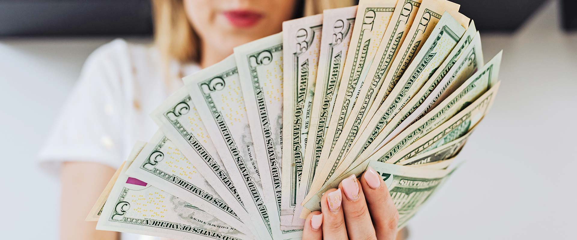 Woman holding Money Fanned out in Hand